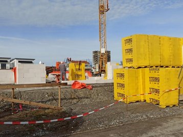 Baustelle mit Baumaterial und Kran