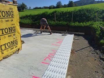 mensch auf Bodenplatte eines Hauses