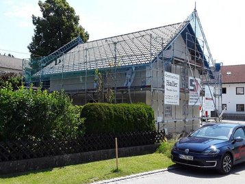 auto vor Haus mit Hecke