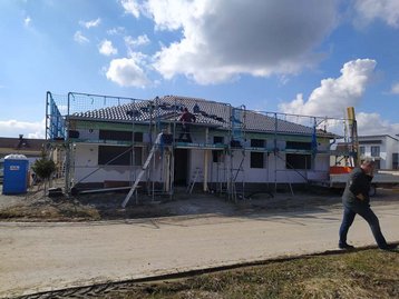 Arbeit eines Dachdeckers an einem Haus mit Gerüst