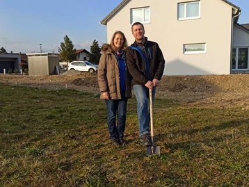 Zwei Menschen auf einem Baugrundstück mit Spaten