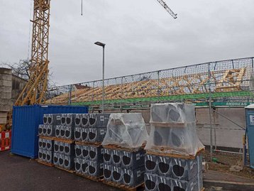 Baustelle mit Materialien, Kran und Haus