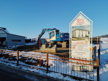 Baugrundstück mit Bagger und Schild
