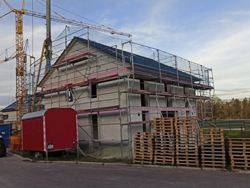Paletten vor einem Haus mit Gerüst
