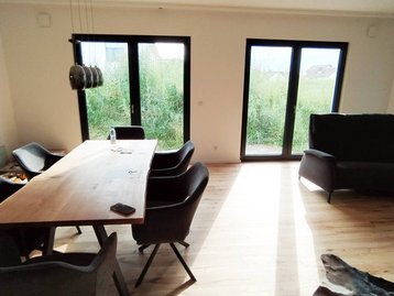 Wohnzimmer mit Tisch und Fenstern