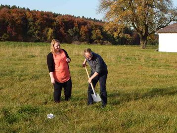 Menschen auf Wiese beim Spatenstich