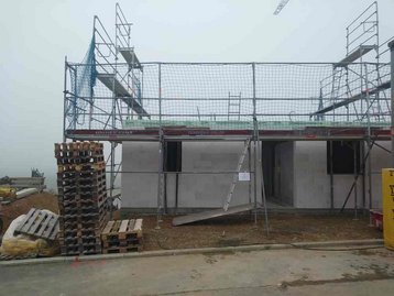 Erdgeschoss wird Gebaut mir Gerüst daneben Paletten