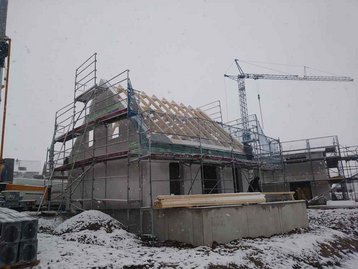 Kran neben Haus zum Dach bauen