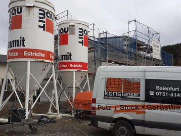 2 Silos neben Haus auf Baustelle