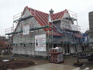 Haus mit rotem Dach und Baugerüst