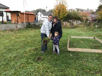 Familie mit Spaten auf Wiese