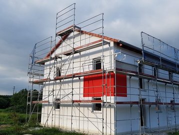 Haus mit Gerüst und rotem balken